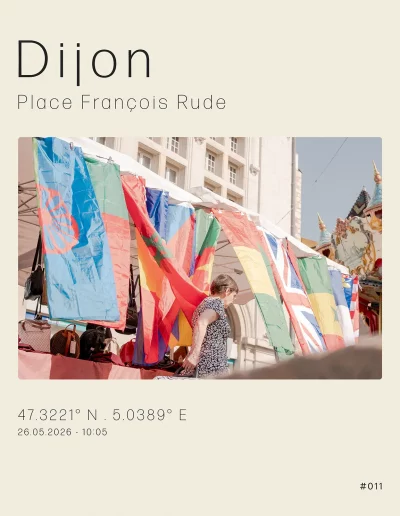 Vu sur un stand de drapeaux, situé sur la place François Rude. Au premier plan, un dame tirant son chariot de courses et en arrière-plan, on peut apercevoir le mythique manège de Dijon.