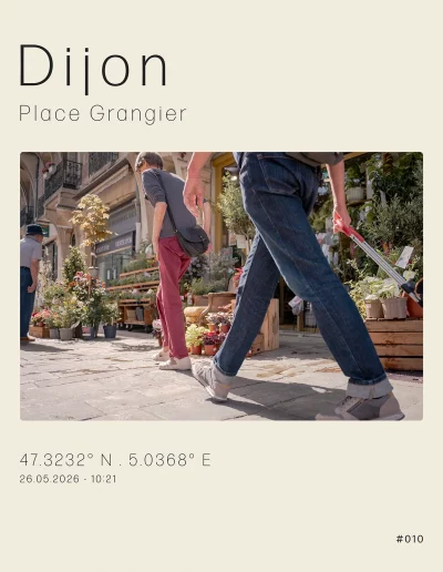 Plusieurs étales de plantes et de fleurs devant cette boutique, place Grangier. Au premier plan, des passants prenant la direction de la rue des Godrans ou de la rue Musette.