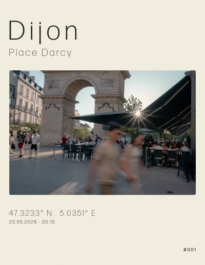 Vue à contre-jour de la place Darcy et de la porte Guillaume. Sur la droite, les terrasses du restaurant l'Edito. Au premier plan, un couple main dans la main traverse la scène.
