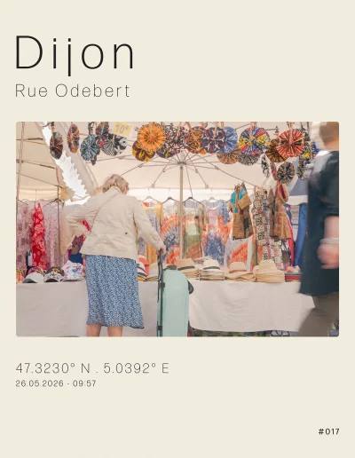 Vue sur un stand de vêtements africains auteur des Halles de Dijon, un jour de marché. Au premier plan, une personne âgée regarde les articles.