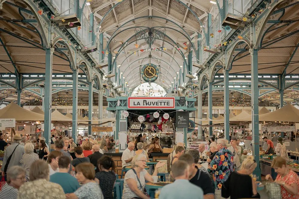 Dijon - La buvette sous les Halles - Marché couvert Vue sur la buvette sous les halles du marché de Dijon. Au premiers plans, des dijonnais boivent un café ou un verre de vin, en ce jour de marché.