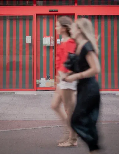 Deux passantes devant la devanture rouge du restaurant Au Roi des Pâtes à Dijon