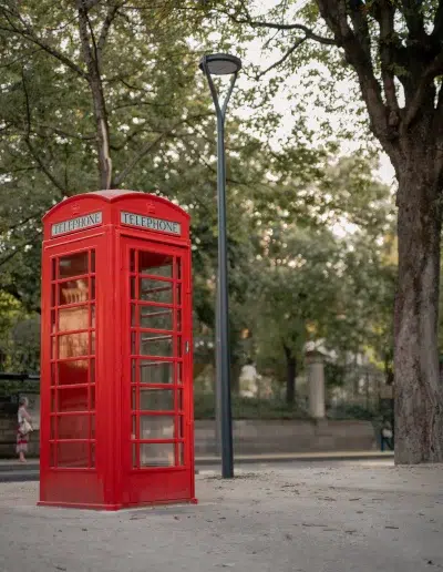 Cabine téléphonique anglaise rouge dans un espace arboré à Dijon