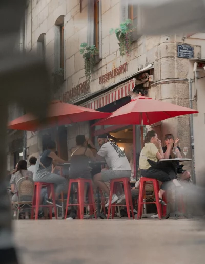 Clients attablés sous des parasols rouges rue Bannelier à Dijon