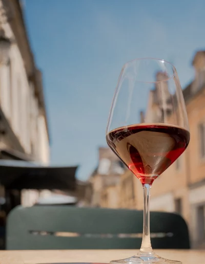 Verre de vin rouge posé en terrasse dans le centre historique de Dijon
